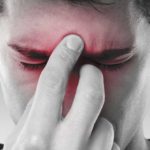 Rinosinusite - ragazzo che soffre di sinusite e si tocca il naso e la fronte