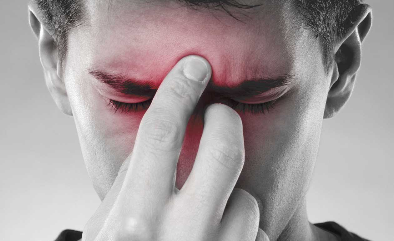 Rinosinusite - ragazzo che soffre di sinusite e si tocca il naso e la fronte