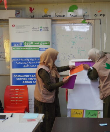 Les volontaires d'ACF en charge de l'hygiene menstruelle devant les residents du camp de refugies d'Azraq en Jordanie. Giornata mondiale del migrante e del rifugiato.