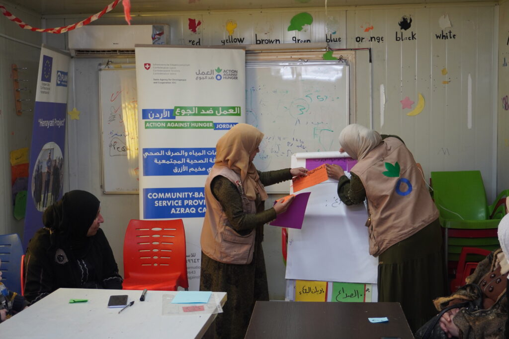 Les volontaires d'ACF en charge de l'hygiene menstruelle devant les residents du camp de refugies d'Azraq en Jordanie. Giornata mondiale del migrante e del rifugiato.